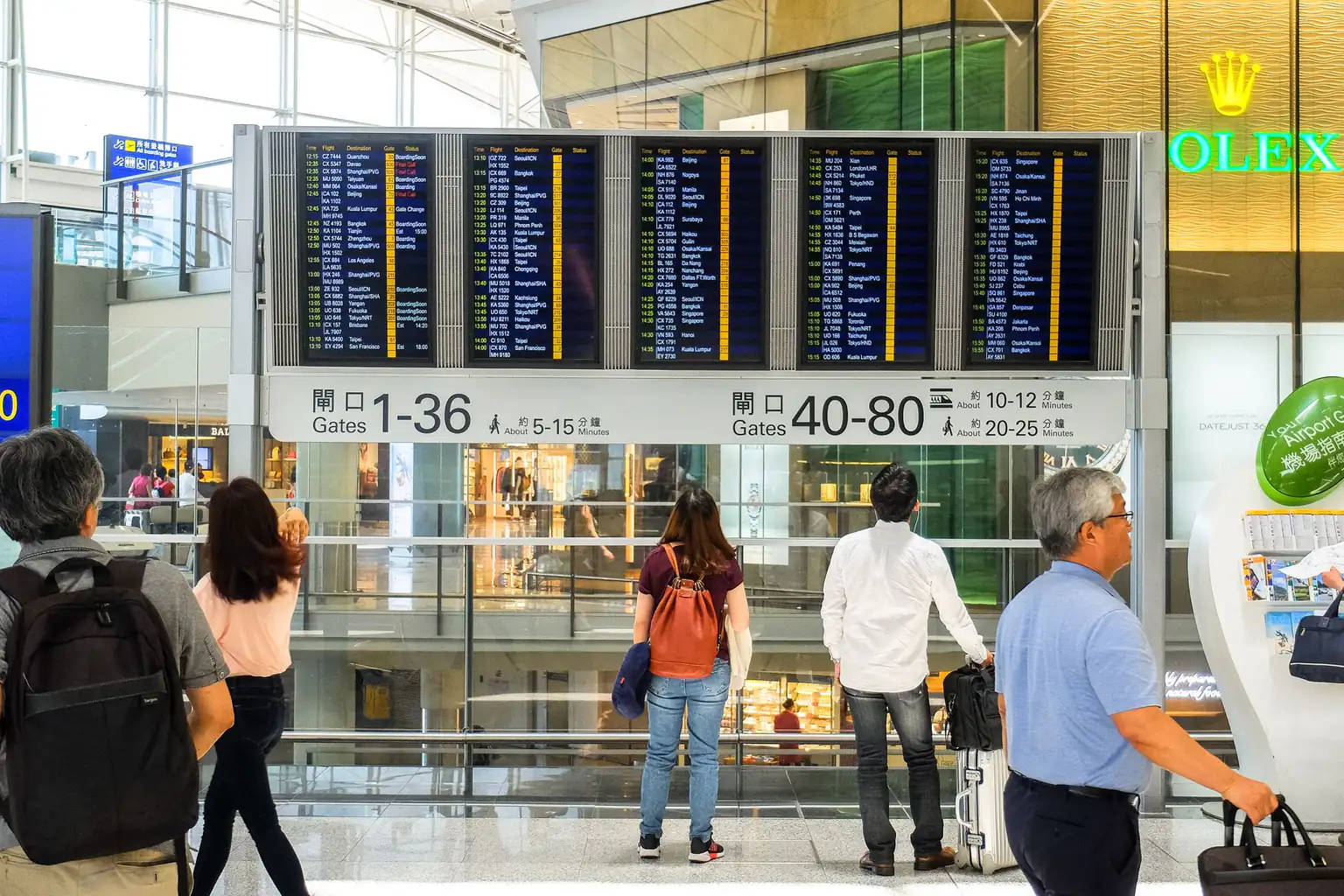A departures board and passengers in a terminal