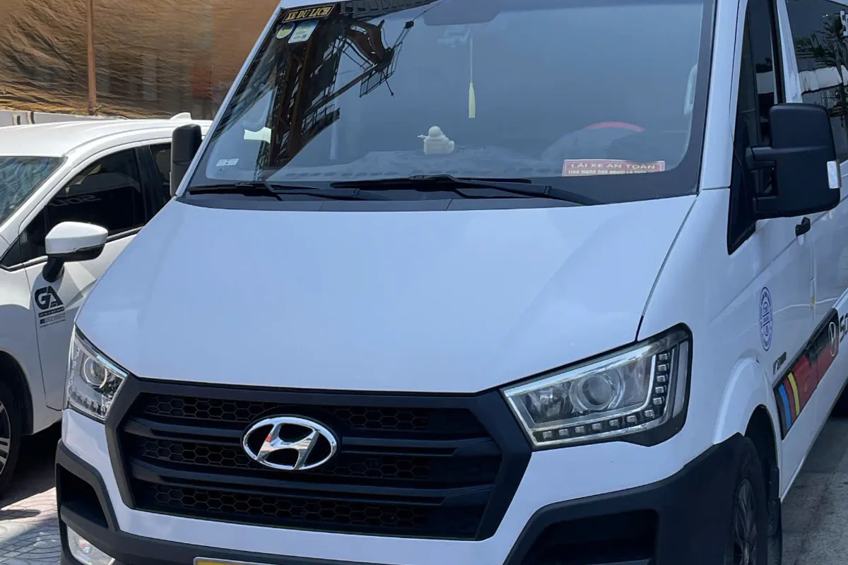 White 16-seat Sun Travel van used for airport and city transfers