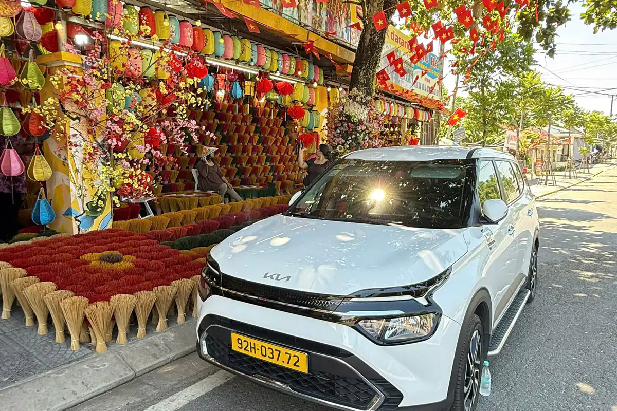White four-seat Sun Travel car at a colourful roadside stop