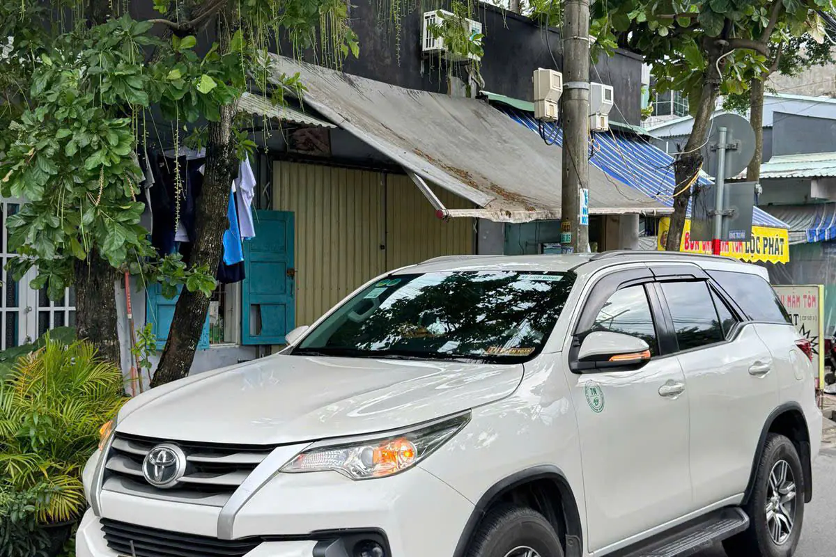 White seven-seat Sun Travel car in a suburban area