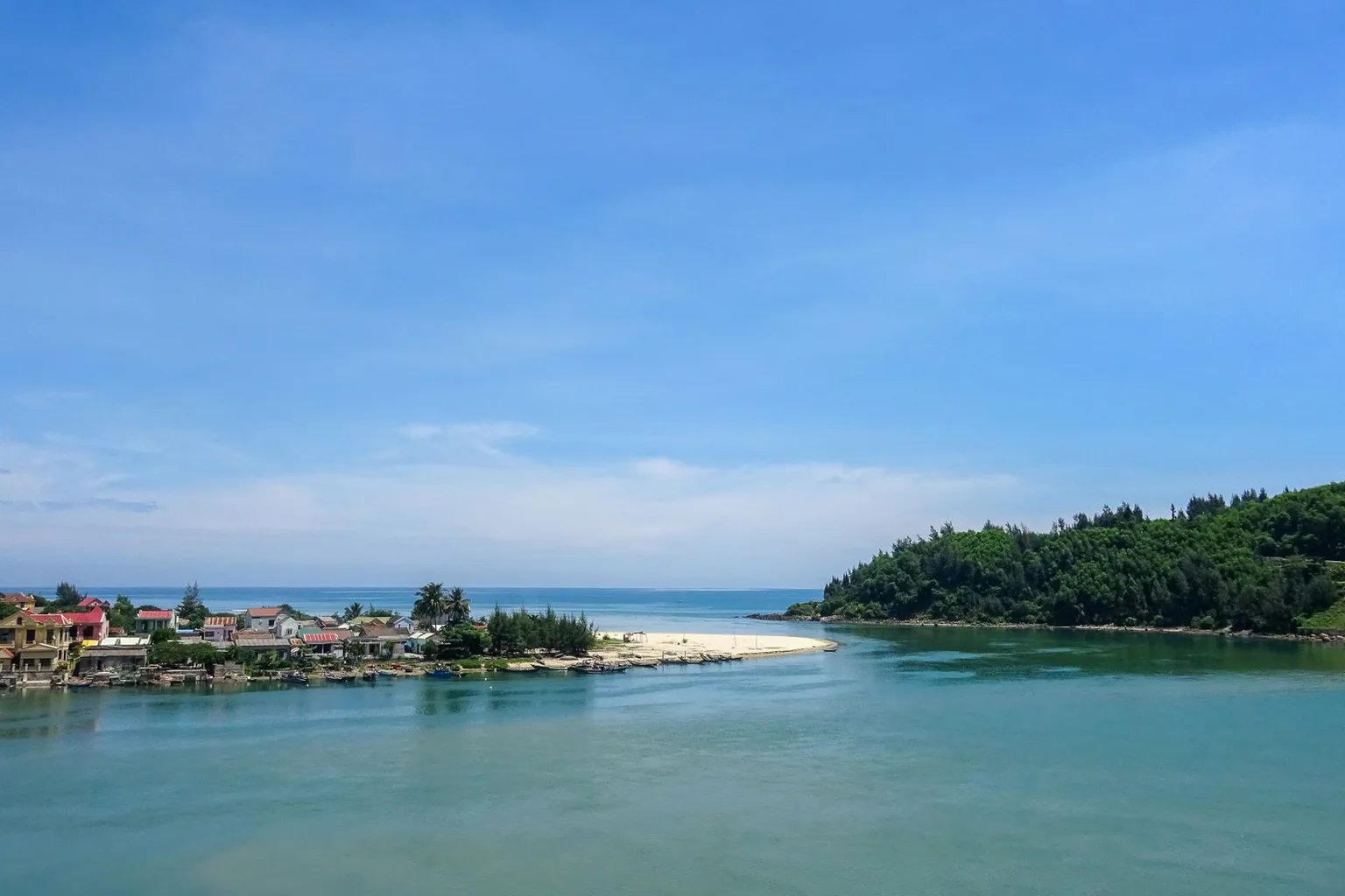 Green sea and peaceful wooded hills along the Lang Co coast