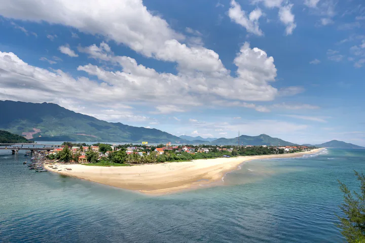 A calm view of Lang Co Bay with mountains and a gently sloping beach