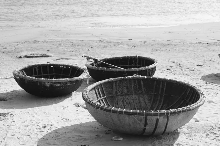 Ba chiếc thuyền thúng truyền thống đặt trên bãi cát